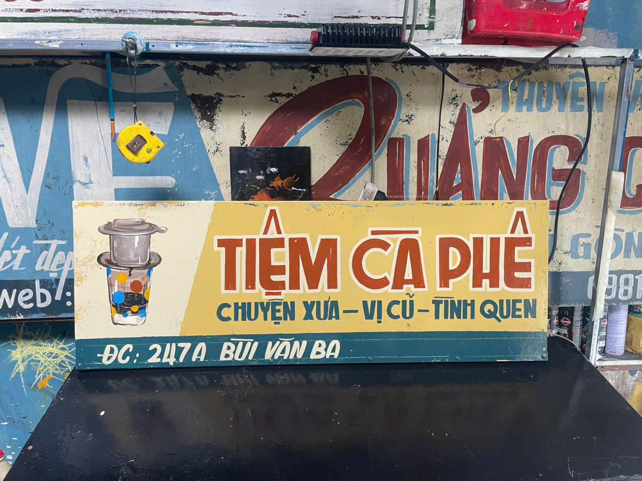 Vespa xanh cổ điển – bảng hiệu vẽ tay tiệm cà phê xưa – không gian đậm chất Sài Gòn hoài niệm. 1 Vẽ bảng hiệu tiệm cà phê xưa phong cách Sài Gòn bên Vespa cổ Bảng hiệu vẽ tay vintage nền vàng chữ đỏ hoài niệm Thiết kế bảng hiệu cà phê retro với minh họa phin truyền thống Bảng hiệu phong cách bao cấp vẽ sơn dầu thủ công