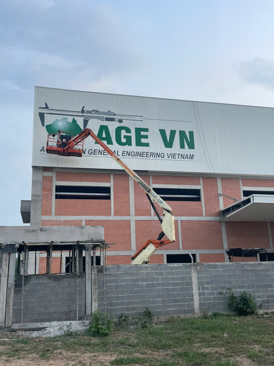 Thi công sơn vẽ logo lên nhà xưởng diện tích lớn, sử dụng sơn ngoại thất cao cấp chống tia UV, bền màu nhiều năm.