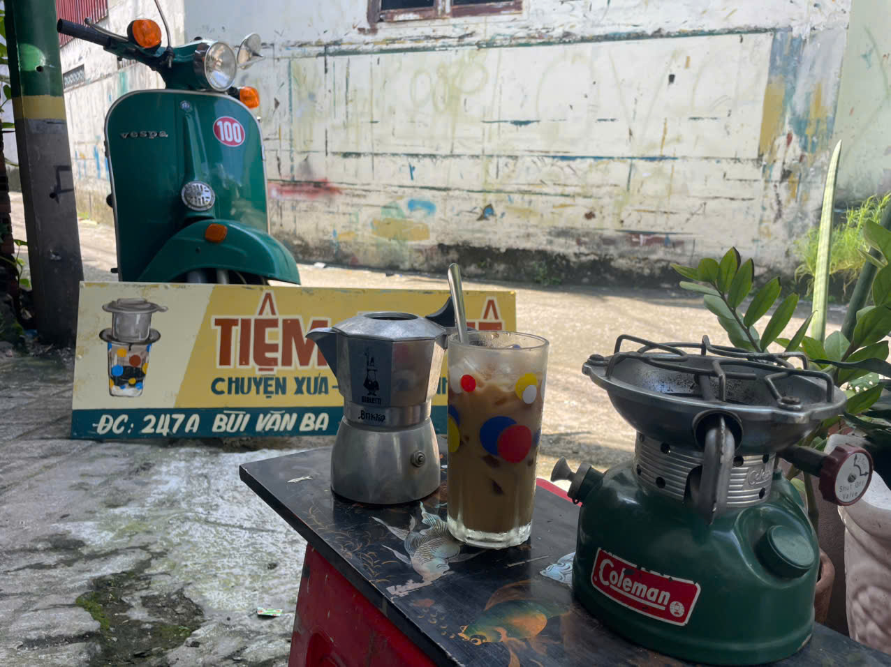 Vespa xanh cổ điển – bảng hiệu vẽ tay tiệm cà phê xưa – không gian đậm chất Sài Gòn hoài niệm. 2 Bảng hiệu vẽ tay vintage nền vàng chữ đỏ hoài niệm